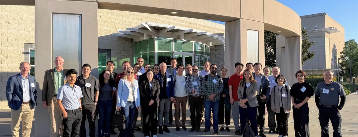 Group photo of more than 50 researchers, agency leaders, and policymakers standing outside the CE-CERT building during the OMEGA Dissemination Workshop, December 11, where CE-CERT presented findings on freight emissions monitoring, air quality impacts, and mitigation strategies in Inland Southern California.