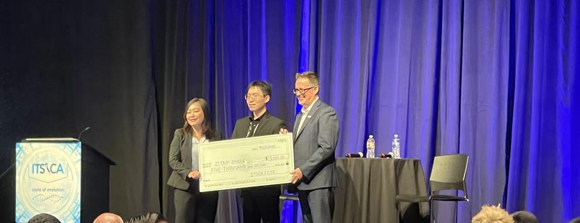 Ziyan Zhang holds a $5,000 scholarship check with two presenters onstage at the 2026 ITS California conference.