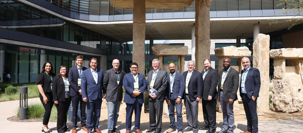 Founding members of the Hydrogen Engine Alliance – North America pose for a group photo in front of the “Petrified Petrol Station” stone art installation at CARB’s Southern California headquarters.