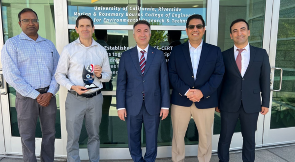 A photo of five men standing in a line outside of the CE-CERT building at UC Riverside. From left to right: Arun Raju, Don Collins (holding a plaque), Prof. İdris Demir, Alfredo Martinez-Morales, and Musa Yilmaz. The photo was taken during Prof. Demir's visit to explore opportunities for international collaboration in energy research and academic exchange.